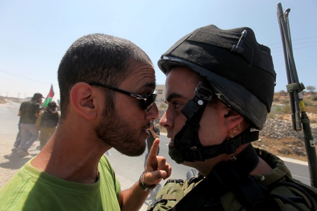 A Palestinian and an Israeli soldier come face-to-face during the eviction of protesters as they were trying to block the main road leading to the Israeli settlment of Efrata, near the West bank town of Bethlehem. Photograph: Abed Al Hashlamoun/EPA