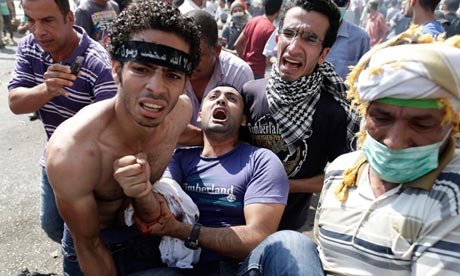 Morsi supporters carry a wounded man during clashes with security forces in Cairo, Egypt