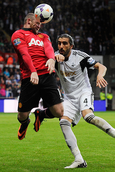 Swansea v United: Wayne Rooney's face contorts as he wins a header 