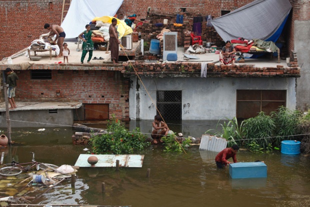 Indians take refuge on the roof of their houses as the river Ganges overflowed after heavy monsoon rains and submerged low lying areas in Allahabad, India.