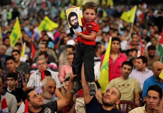 Hezbollah supporters hold up a boy with a portrait of the late Hezbollah leader Sheik Abbas al-Moussawi, during a rally to mark Jerusalem day or Al-Quds day, in a southern suburb of Beirut, Lebanon.