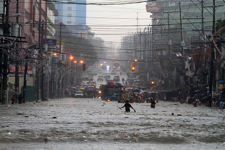 Manila floods: Residents wade through a water-logged street in Quezon City