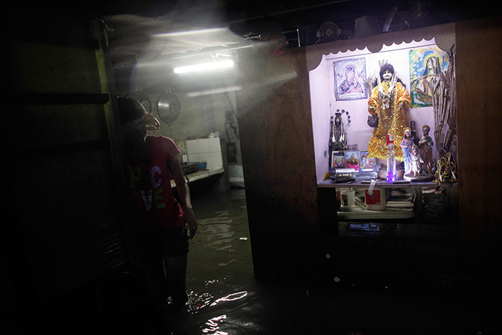 Manila floods: A resident takes a break in her flooded house in Sucat