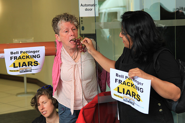 Fracking protest: Locked-on activist is fed grapes by a fellow protester