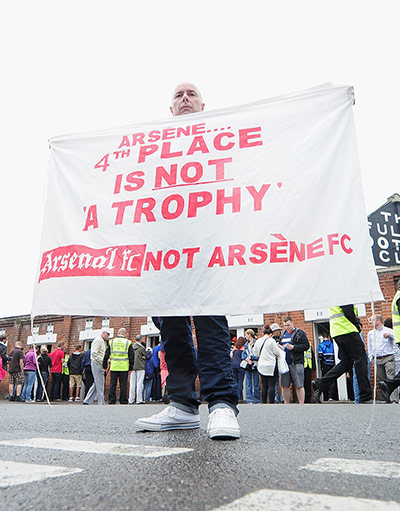 Saturday Round up: Fan with banner against Arsene Wenger
