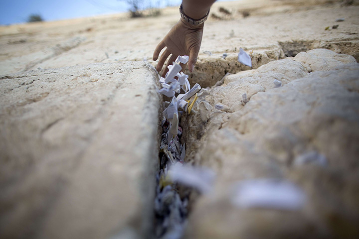 Weekend in pictures: A Western Wall employee removes messages