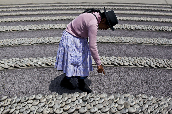 Weekend in pictures: Lima, Peru: A woman points at a stone with the name of her relative killed 