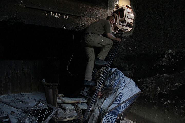 Weekend in pictures: Aleppo, Syria: A member of the Free Syrian Army climbs a ladder inside a ho
