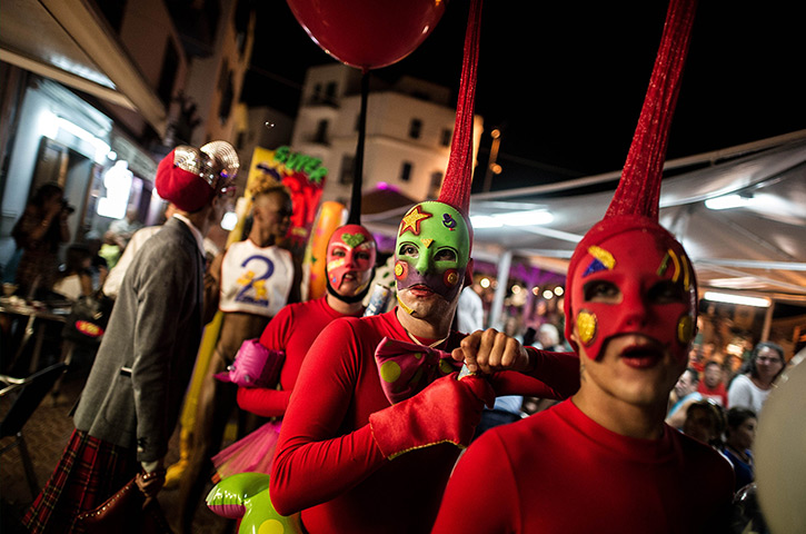 Ibiza summer: Go-go dancers and publicity people from Ibiza's main clubs walk through the