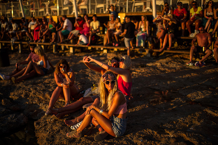 Ibiza summer: Tourists gather to watch the sunset in front of Cafe del Mar in Sant Antoni