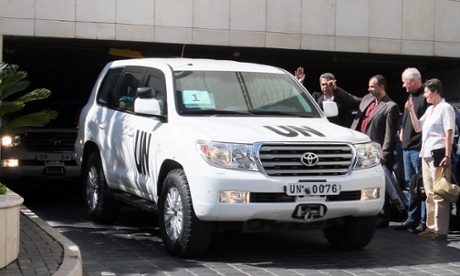 UN inspectors raise their thumbs as they watch the departure of the inspection team at the Four Seasons hotel on 27 August, 2013 in Damascus, Syria.