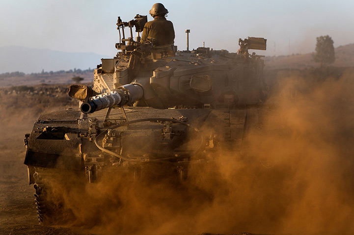 Israel preparations: Israeli soldiers drive a tank at a staging area in the Golan Heights