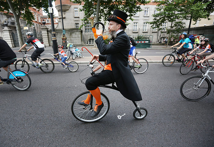 RideLondon: A man on a Penny Farthing style bicycle while blowing a horn