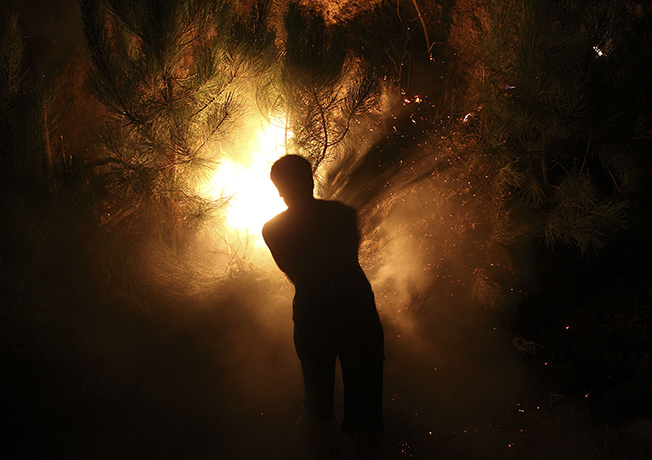 Wildfires in Portugal: Local people trying to extinguish a wildfire in Santiago de Besteiros
