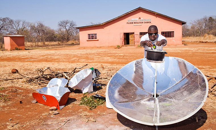 Reforestation in Zambia: A cook prepares nshima (maize porridge) on a parabolic solar cooker