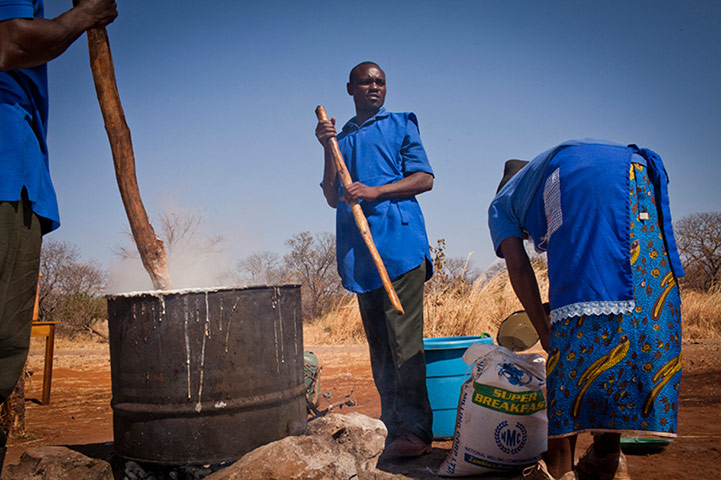 Reforestation in Zambia: Local volunteers prepare nshima (maize porridge) during a plant day