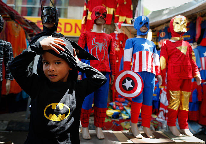 Weekend Pictures: Kuala Lumpur, Malaysia: A boy tries on Batman's costume before Eid al-Fitr 