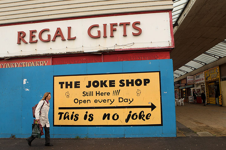 UK Seaside Towns: A woman walks past a boarded-up shop on Margate's promenade 