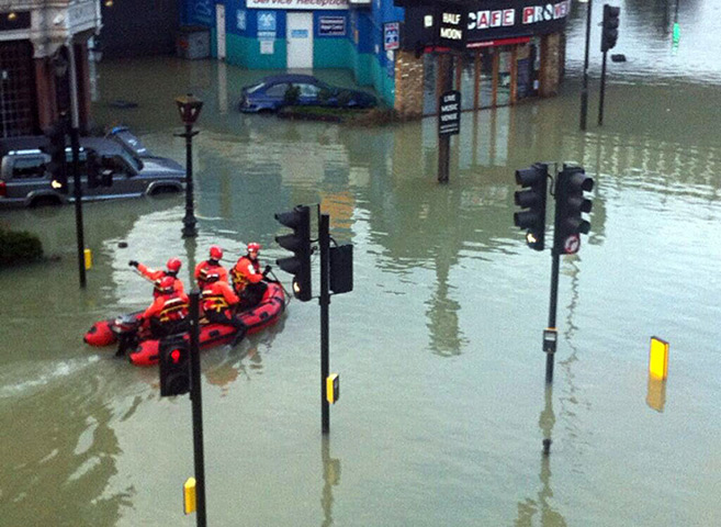 Herne Hill flood: Man trying to get a ride to work on passing rescue boat.