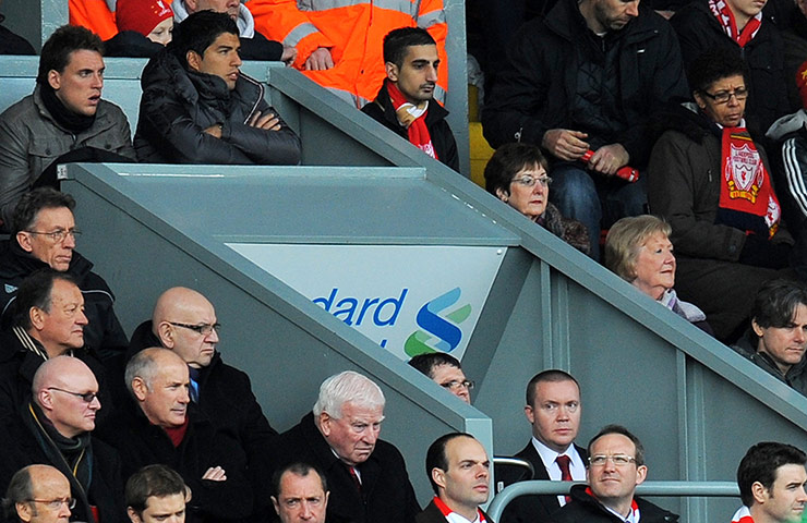 Liverpool's Luis Suárez watches from the directors box during his ban