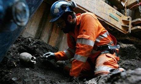 An archaeologist unearths a human skull at the Crossrail building site at London's Liverpool Street
