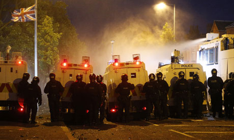 Riot police deploy a water cannon after being attacked by loyalist protesters in Belfast on 13 July