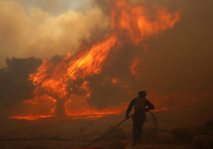 20 Photos: A Greek firefighter at a forest fire raging in Marathon near Athens