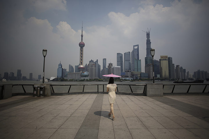20 Photos: A woman uses a parasol in the afternoon heat at the Bund