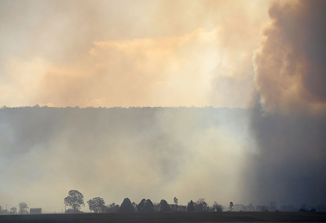 West Sydney bushfires: Firefighters and media crew at the site of a grass fire in northwest Sydney