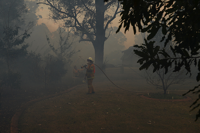 West Sydney bushfires: RFS volunteers mop up at the bcd of houses on Santuary Drive