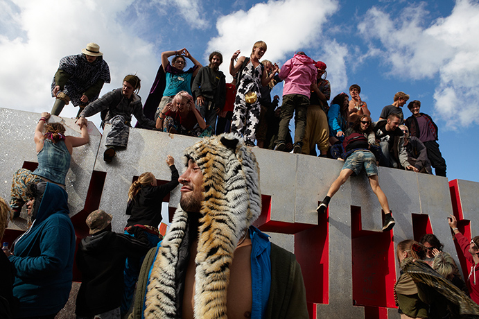 Bestival: Festival goers climb the Bestival sign