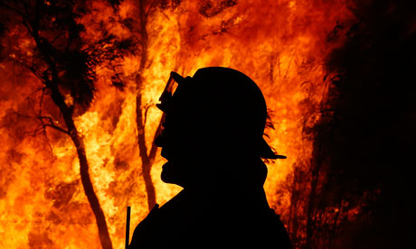A firefighter gives instructions near a bushfire 