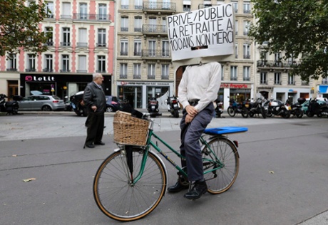 A man on his bicycle attends a demonstration over pension reforms in Paris, September 10, 2013. French unions take to the streets on Tuesday in protest against a reform of the country's indebted pension system, with some disruption in transport expected but no mass upheaval against an overhaul seen as moderate in scope. The placard reads 