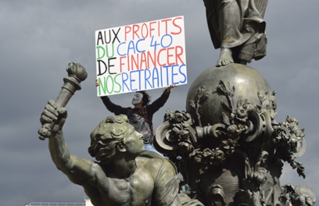 A person holds a placard from the Republic square statue, during a protest against the government's plans to reform France's debt-ridden pension system, on September 10, 2013 in Paris. C