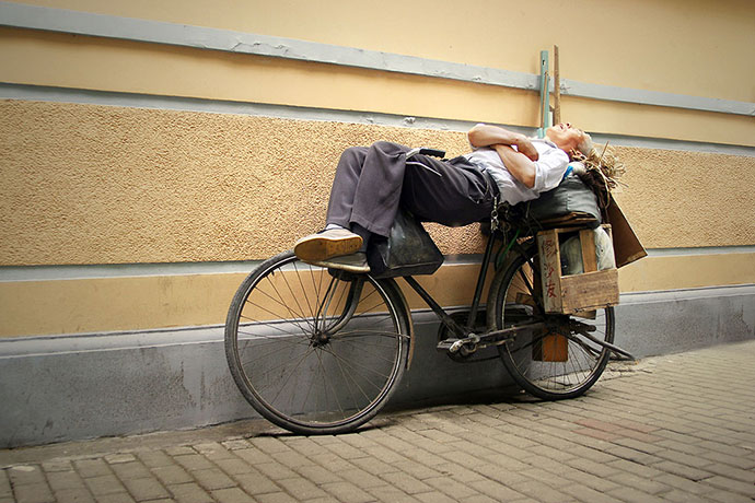 Big Picture - Daydreamers: man lying on bicycle sleeping