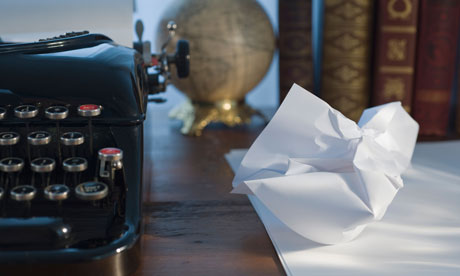 Crumpled writing paper next to a typewriter