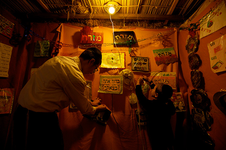 Sukkot preparations: Jewish children put up decorations in their family sukkah in Salford