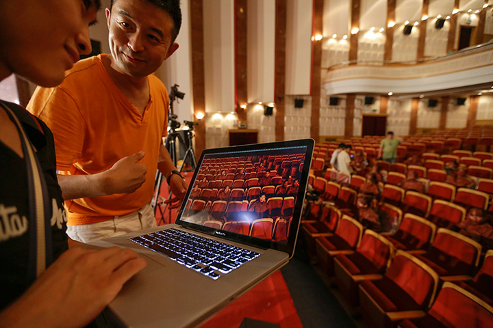 FTA: Jason Lee: Artist Liu Bolin and his assistant examine an image during Liu's latest pro