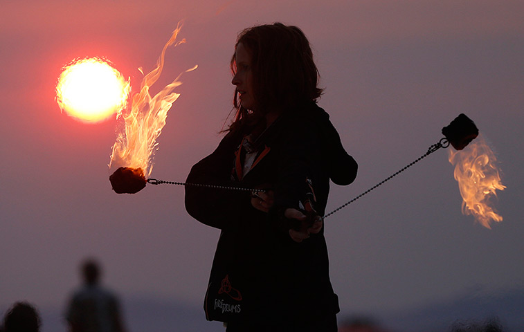 Burning Man 2013: A woman performs with fire at sunrise at the Temple of Whollyness 