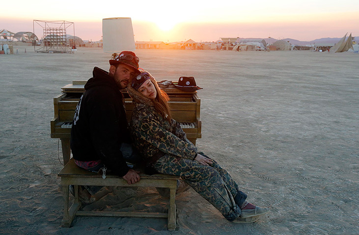 Burning Man 2013: A couple sit at a piano at a desert art installation 