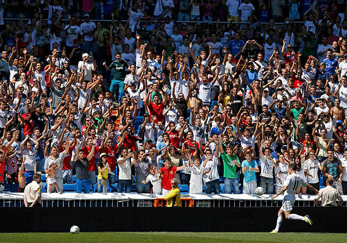 Bale arrives in Madrid: Gareth Bale of Wales kicks a ball to crowd at the famous Santiago Bernabeu 