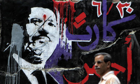 A man walks past graffiti of ousted Egyptian president Mohamed Morsi in central Cairo