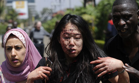 A wounded woman is helped to safety after gunmen opened fire in a shopping centre in Nairobi, Kenya