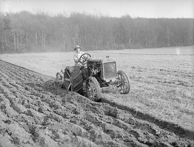 Woman 'land girl' driving a tractor