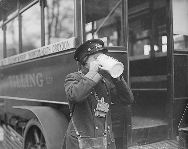 Woman bus conductor has a warm drink