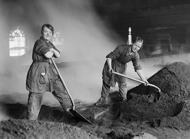 Women workers feed a charcoal kiln used for purifying sugar