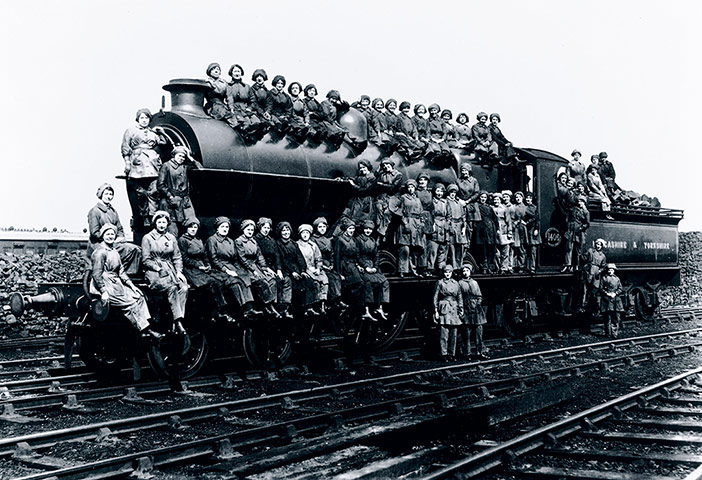 Women cleaners pose on a railway locomotive in West Yorkshire