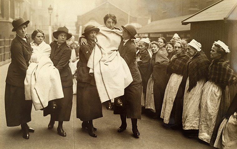 Workhouse women watch female workers practice firefighting