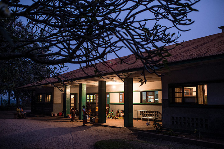 Making babies: Women wait outside a health centre in Mosango as dusk falls