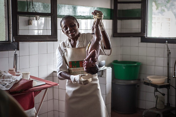 Making babies: A midwife holds up a newborn baby 